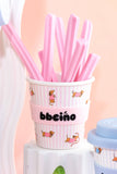 Cup with pink straws and 'bbeeino' branding on a light pink background