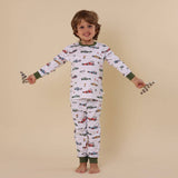 Child wearing pajamas with vehicle pattern on a beige background