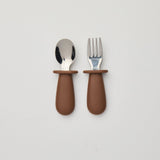 Set of spoon and fork with brown handles on a light gray background