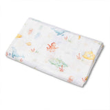 A folded white muslin baby swaddle blanket featuring a colorful watercolor underwater print with sea creatures like a blue whale, octopus, jellyfish, and fish, shown on a plain white background.