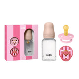 Baby bottle and pacifiers set with pink packaging on a white background