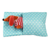 Stuffed dog toy in a blue polka dot bag on a white background