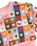 Colorful checkered fabric with heart patterns on a pink background