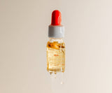 Bottle of skincare serum with a red dropper on a beige background