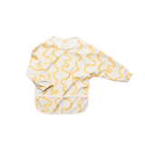 A long-sleeve baby bib with a yellow wavy line pattern on a cream background, featuring a front pocket and elastic cuffs.