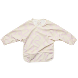 A long-sleeve baby bib in cream with a light pink wavy pattern, featuring a front pocket and elastic cuffs.