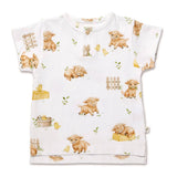 A white short-sleeve baby t-shirt with a cute watercolor print of sheep, chicks, fences, and small plants. The shirt features a three-button henley neckline and is displayed flat against a clean white background.