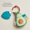 Avocado-shaped teething toy with pacifier clip on a beige background