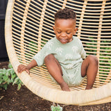 Child sitting in a wicker chair outdoors