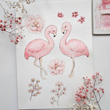 A watercolor-style art print featuring two pink flamingos and pink flowers on a white background, styled with dried baby's breath flowers around it.