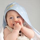 Baby wrapped in a light blue hooded towel with a neutral background