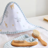Baby care set with towel, comb, and brush on a white surface