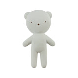 A minimalist white teddy bear figurine with small brown eyes, nose, and ears, standing against a solid white background.