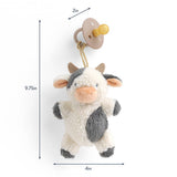 Plush cow toy with a pacifier attachment and measurements on a white background