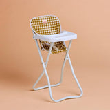 Foldable high chair with a checkered cushion on a beige background