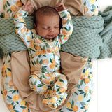 Newborn baby sleeping in a floral-patterned crib