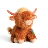 Plush toy highland cow with a colorful necklace on a white background