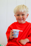 Child wearing a red sweatshirt holding a cup with a white background