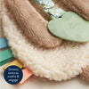 Close-up of a soft toy with textured elements on a fluffy surface, featuring sensory texturalsoothe & engage.