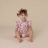 Child wearing a floral outfit on a beige background