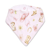 A light pink triangular bandana bib featuring a western-themed print with cowboy boots, a pink cowboy hat, bows, flowers, and a horseshoe, displayed on a clean white background.