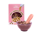 Box of Tiny Chocco Loops cereal with a bowl of cereal and pink spoon on a white background