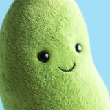 Plush avocado toy with a smiling face against a blue background