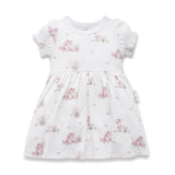 White dress with pink floral pattern on a white background