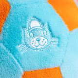 Close-up of a plush toy with a cat face design on a blue and orange background