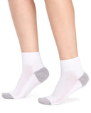 A pair of low-cut white socks with gray heels and toes, shown on a person's feet against a plain white background.