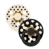 Two baby pacifiers with polka dot design on a white background