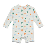 A baby long-sleeve footless romper in off-white with a colorful tropical print of palm trees, seashells, suns, and waves, shown flat on a white background.