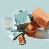 Cosmetic products and a glass of iced tea on a light blue background