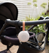 White baby monitor with pink strap attached to a stroller handle