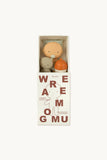 A boxed set of Wramo Gumu handmade natural toys, featuring a peach-colored rattle, a gray bear, and an orange bottle, presented in a white box with brown lettering on a light background.