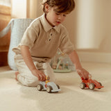 Child playing with toy cars on a carpeted floor