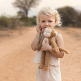 Young girl holding a teddy bear in an outdoor setting
