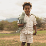 Child holding a stuffed animal in an outdoor setting