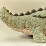 Plush toy alligator on a beige background