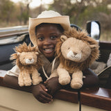 Child holding two lion plush toys with a safari vehicle in the background