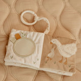 Children's book with a teething ring on a soft beige background