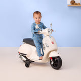 Child on a toy scooter against a light blue wall