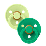 Two baby pacifiers, one green and one light green, on a white background.