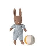 Stuffed rabbit toy in a knitted outfit with a ball on a white background
