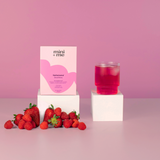 Pink candle and 'mini + me' box with strawberries on a pink background