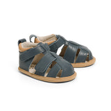 Pair of blue sandals with brown soles on a white background