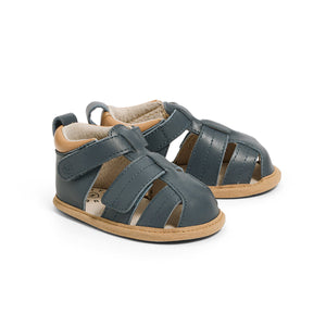 Pair of blue sandals with brown soles on a white background