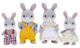 Four toy bunnies in various outfits on a white background