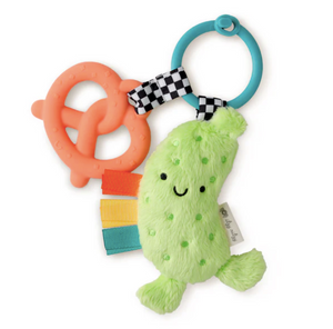 A plush pickle toy with a attached silicone teether and colorful ribbons, all connected by a black and white checkered ring.