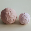 Two pink textured balls on a light background